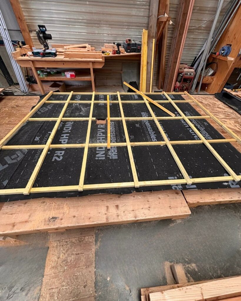 Élément d’ossature bois en cours d’assemblage sur une table de travail dans un atelier