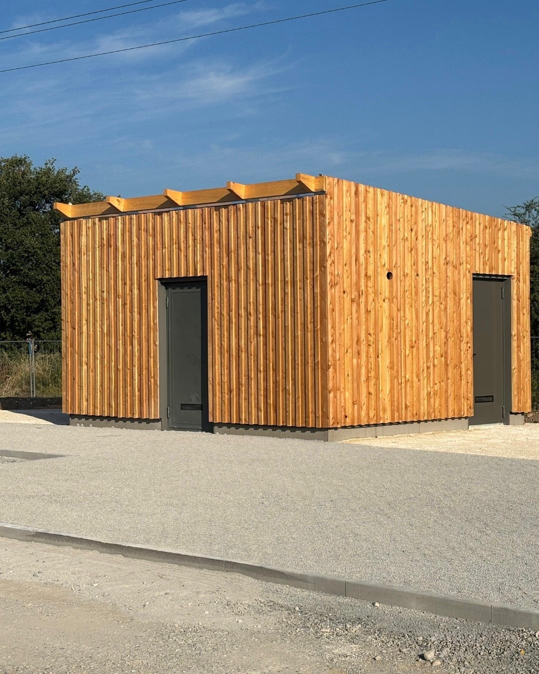 bâtiment en ossature bois installé sur un terrain aménagé.